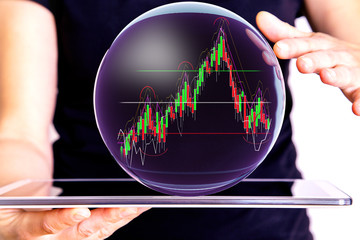Hand holding tablet pc with glass globe and chart