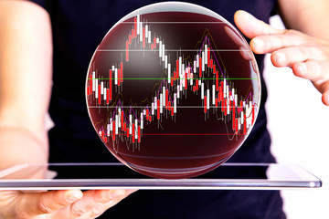 Hand holding tablet pc with glass globe and chart
