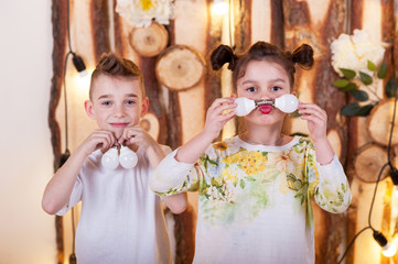 Little boy and girl play LED bulbs. They are holding light bulbs