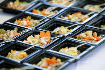 Serie di antipasti serviti elegantemente su vassoi neri in tavola