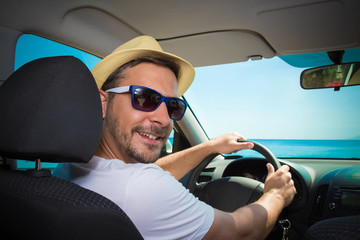 Portrait of tourist guy in car. Travel and summer vacation concepts.  