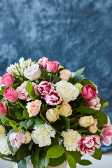 Flower arrangement with tulips and ranunculus on a white wooden floor. Spring flower 