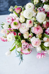  Flower arrangement with tulips and ranunculus on a white wooden floor. Spring flower 