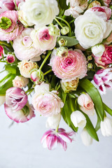  Flower arrangement with tulips and ranunculus on a white wooden floor. Spring flower 