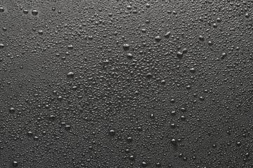 Drops of water on a black surface. The condensate. Top view. Free space.