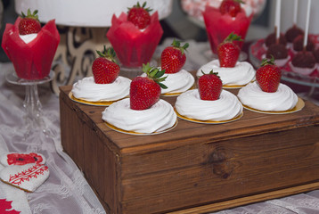 Cakes with strawberries and cream on the wedding table. Dessert