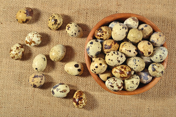 Quail eggs in a wooden bowl in a sacking