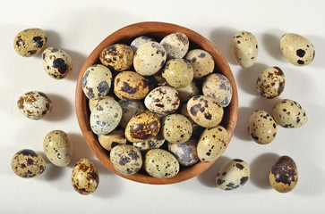 Quail eggs in a wooden bowl in a sacking
