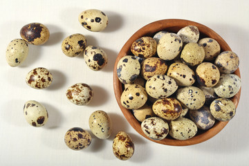 Quail eggs in a wooden bowl in a sacking