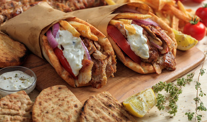 Greek gyros wrapped in pita breads on a wooden table