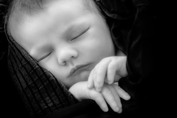 beautiful baby looking out from under blanket 