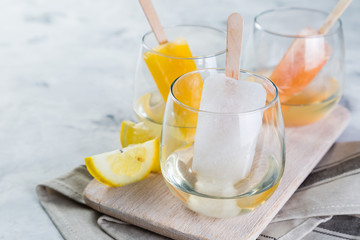 Colorful ice popsicles with wine in glasses