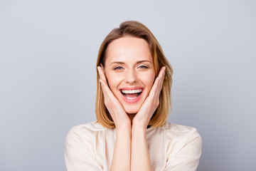 Close up portrait of funny cute young woman laughing and touching her cheeks