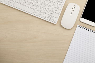 Modern working business desk with keyboard, mouse, smart phone & notepad. Top view with copy space