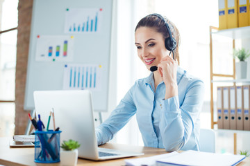 Portrait of young smiling happy woman in headphones working as operator of call center