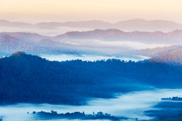 High angle view over tropical mountains with white fog in early morning in Thailand.