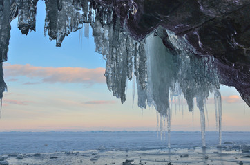Ледяной грот на скалистом берегу острова Ольхон в районе метеостанции Узуры на закате. Озеро Байкал в сумерки
