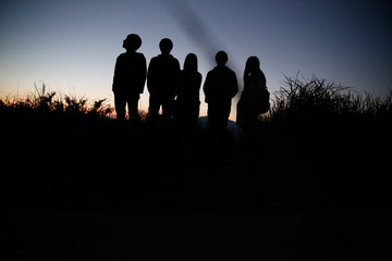 Watch the evening with a group on a hill