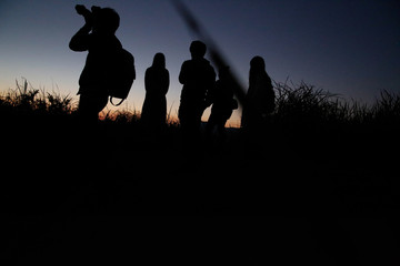 Watch the evening with a group on a hill