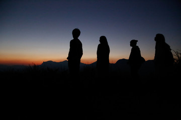Watch the evening with a group on a hill