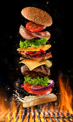 Flying burger ingredients above grill - obrazy, fototapety, plakaty