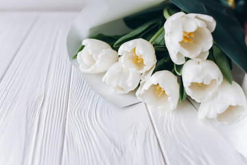 Obraz na płótnie Canvas Mother's Day . white tulips on white wooden background