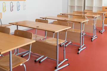Empty classroom with wooden desks and chairs