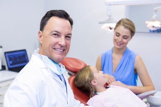 Dentist smiling at camera in dental clinic