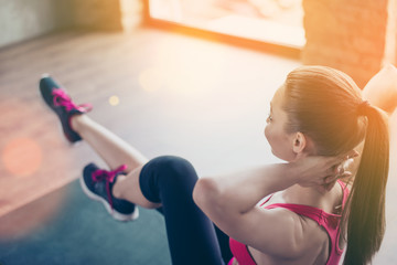 Love sport. Close up photo of girl training on the green mat in sunny room. Girl is wearing sportsclothes and sneakers