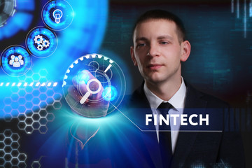 Business, Technology, Internet and network concept. Young businessman working on a virtual screen of the future and sees the inscription: Fintech