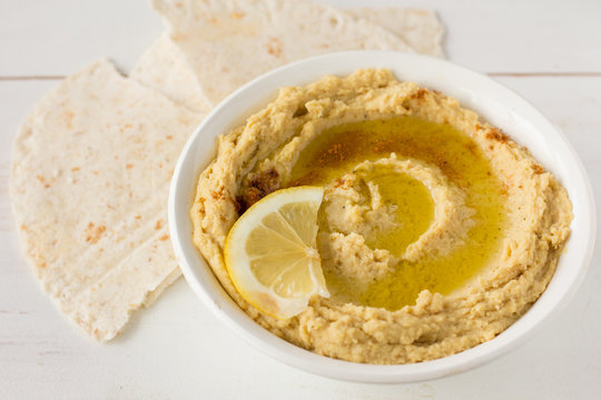 Hummus with spices and lemon in white bowl