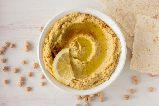 Hummus with spices and lemon in white bowl