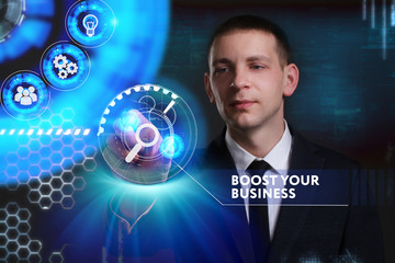 Business, Technology, Internet and network concept. Young businessman working on a virtual screen of the future and sees the inscription: Boost your business