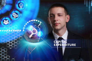Business, Technology, Internet and network concept. Young businessman working on a virtual screen of the future and sees the inscription: Capital expenditure
