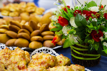 Small pies lie on a plate with basket of flowers