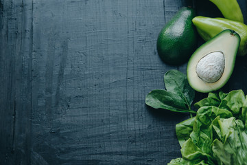 Vegetable wall paper on black board background: Spinach, avocado, lettuce and pepper. Diet/healthy/detox food concept. Space for text