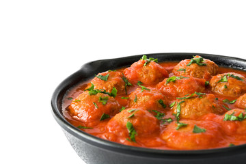 Meatballs with tomato sauce in iron frying pan isolated on white background

