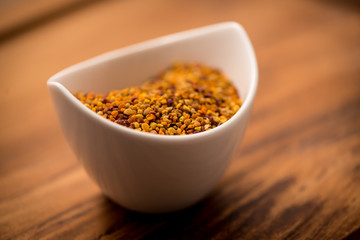 Bee Pollen in a bowl on a wooden surface