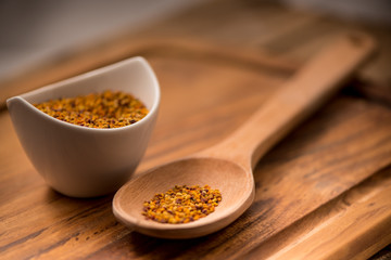 Bee Pollen in a bowl on a wooden surface