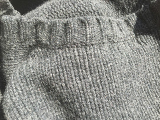 Close-up photo of black grey knitted crumpled textured surface background