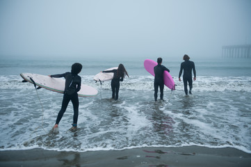 Family entering the water to go surfing