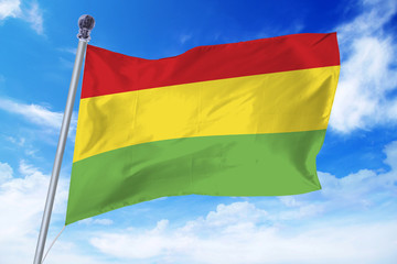 Flag of Bolivia developing against a clear blue sky