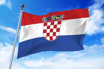 Naklejka premium Flag of Croatia developing against a clear blue sky