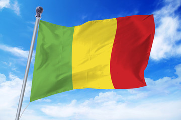 Flag of Mali developing against a clear blue sky