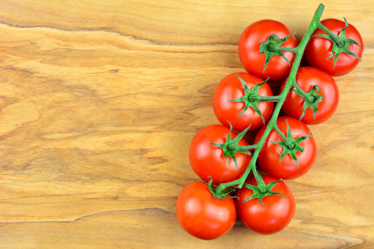 Tomaten - Rispentomaten am Holztisch mit Textfreiraum