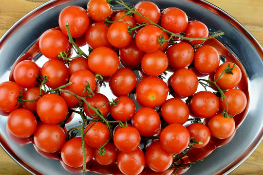 Tomaten - Cocktailtomaten mit Rispe auf einem Serviertablett