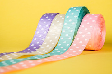 Fototapeta premium Closeup of ribbon roll over colorful background