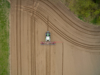 tractor - aerial view of a tractor at work cultivating a field in spring
