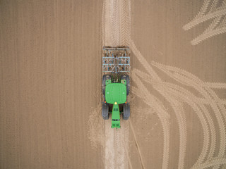 tractor - aerial view of a tractor at work cultivating a field in spring