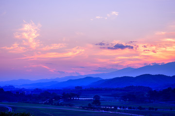 Colorful sunset sky with cloud over mountain landscape